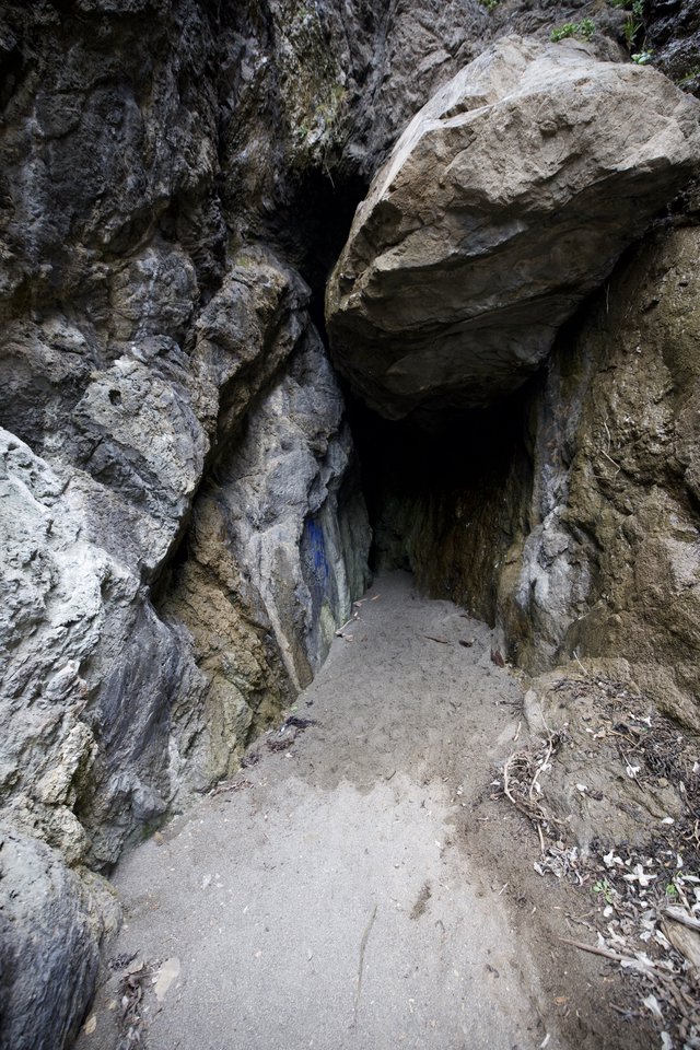 Dark Passage Into Ancient Rocky Cave Entrance