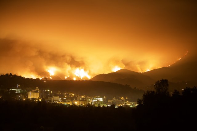 Flames Engulf Mountain and Cityscape