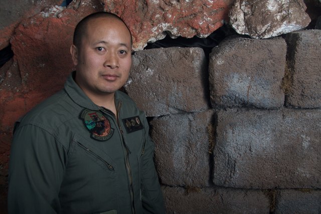 Military Man Standing by a Brick Wall