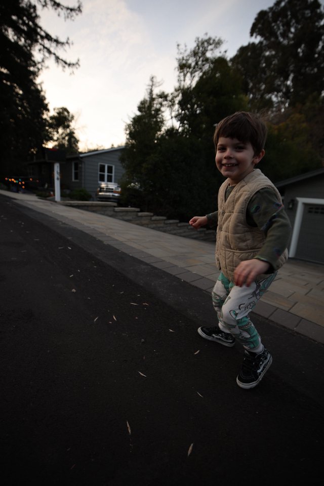 Young Boy Playing on Suburban Street at Dusk