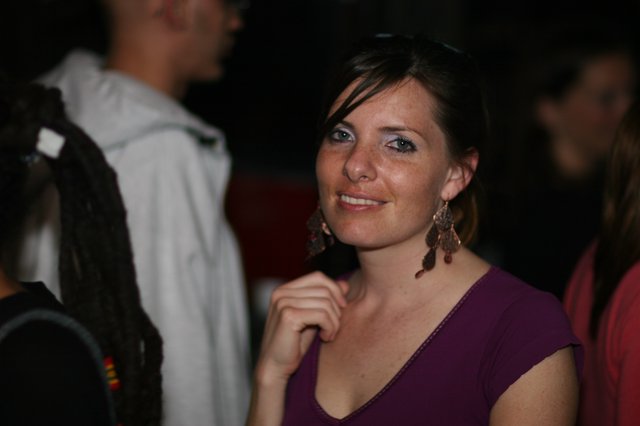 Smiling Woman at a Nighttime Social Gathering