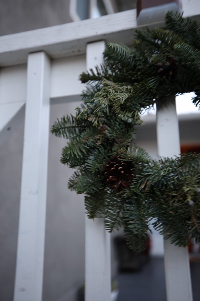 Evergreen Garland on White Porch Railing with Pine Cone