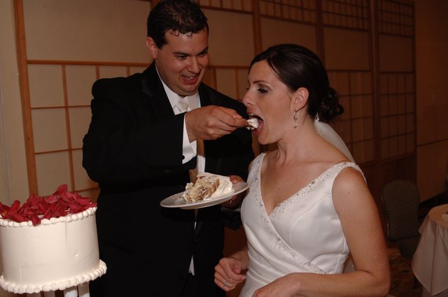 Bride and Groom Share First Slice of Wedding Cake