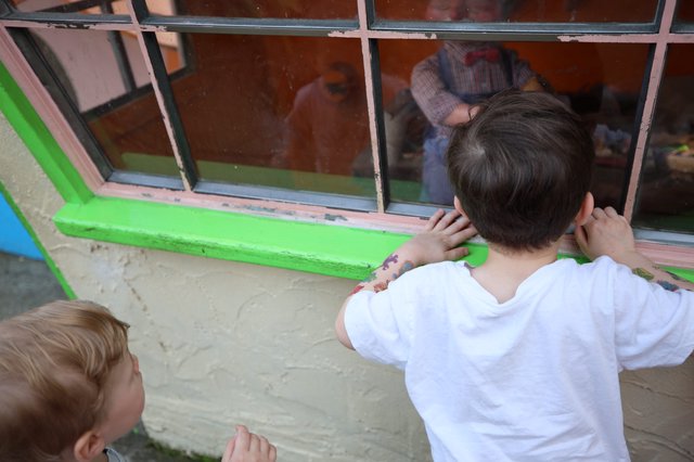 Children Peering Through Window at Fantasyland