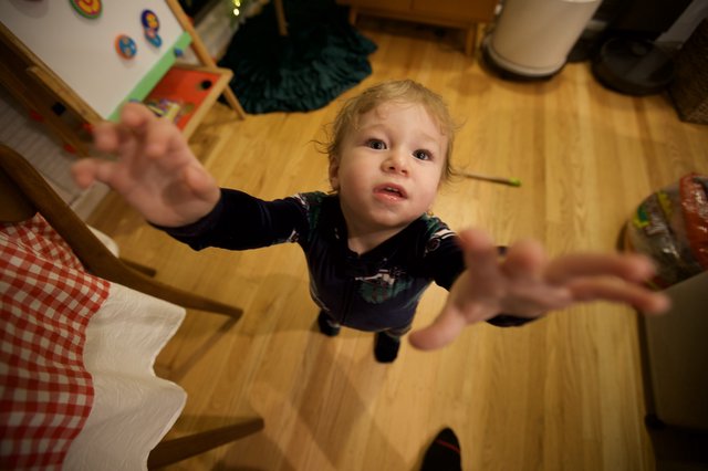 Toddler Reaching Up Toward Camera on Christmas Morning