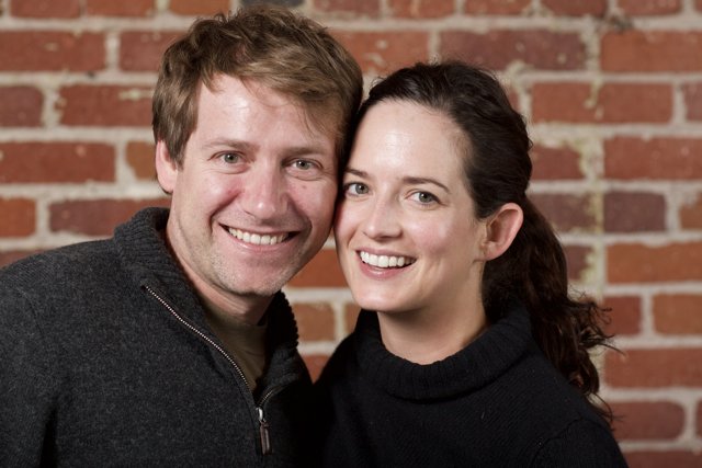 Smiling Couple Against Brick Wall