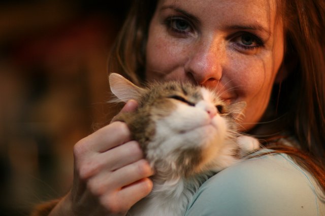 Woman Tenderly Cuddling Fluffy Kitten Close to Face
