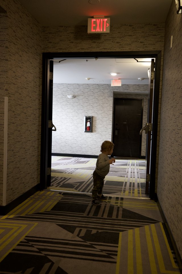 Toddler Exploring Modern Hotel Hallway at Night