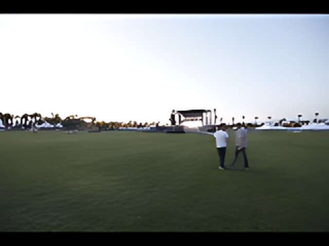 Stage and People on Grassy Field