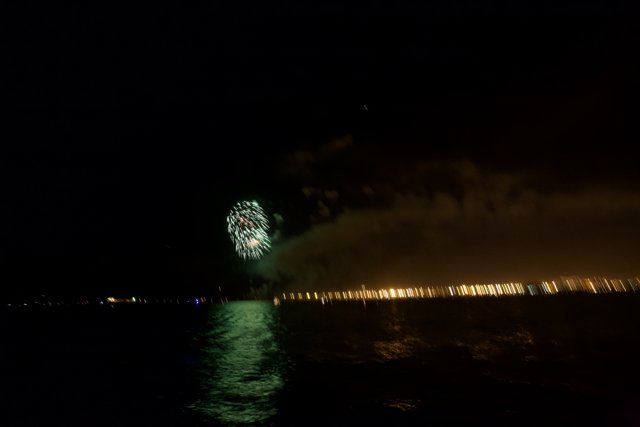 Sparkling fireworks illuminating the night sky over the water