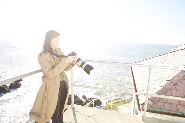 Photographer Capturing Coastal Scenes with Professional Camera