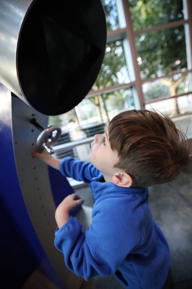 Young Boy Exploring Interactive Exhibit at Science Center
