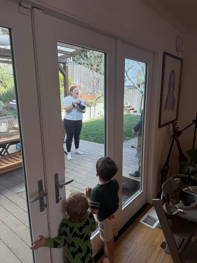 Mother and Children Sharing a Moment Through Glass Door