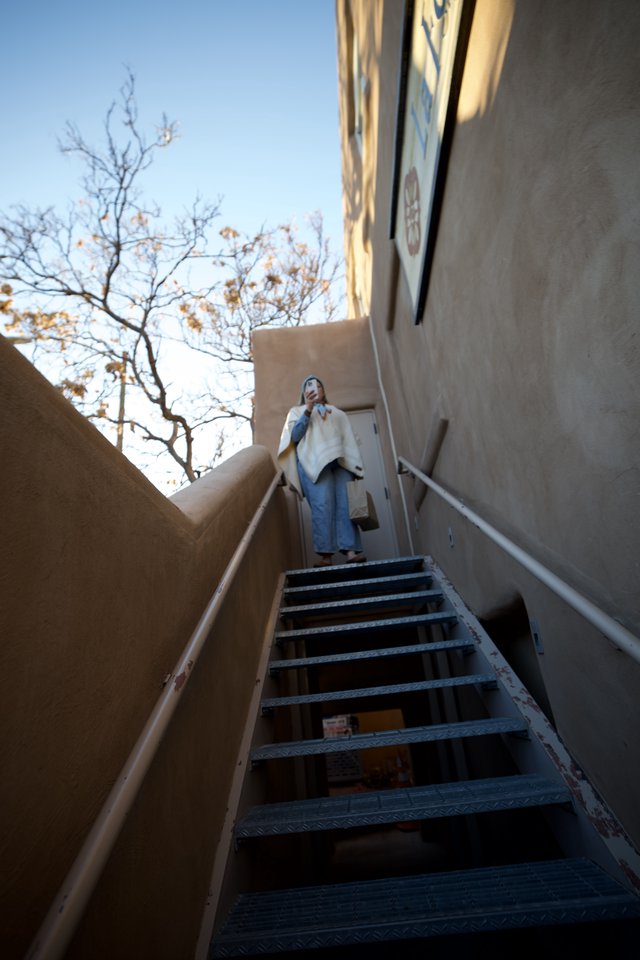 Upward Perspective: Woman at Top of Metal Staircase