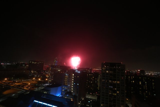 Cityscape Illuminated with a Flare of Fireworks
