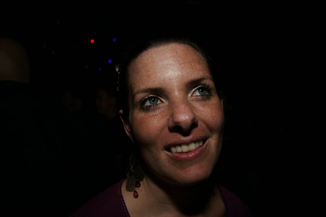 Smiling Woman in Dimly Lit Event Venue