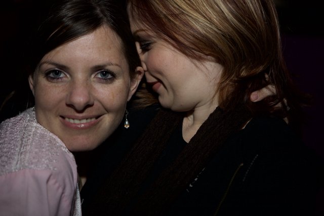 Two Friends Share a Whispered Secret at Night