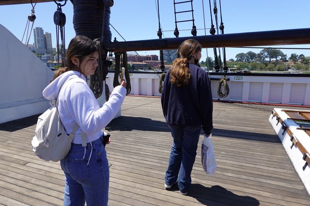 Tourists Exploring Historic Sailing Ship Deck