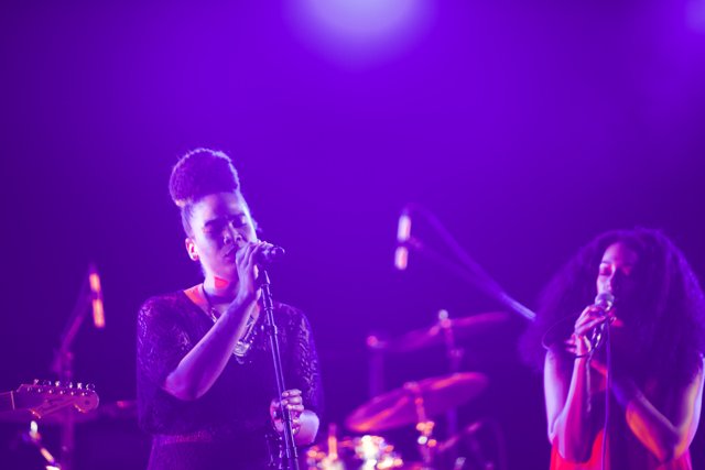 Two Women Rocking the Stage with Purple Lights