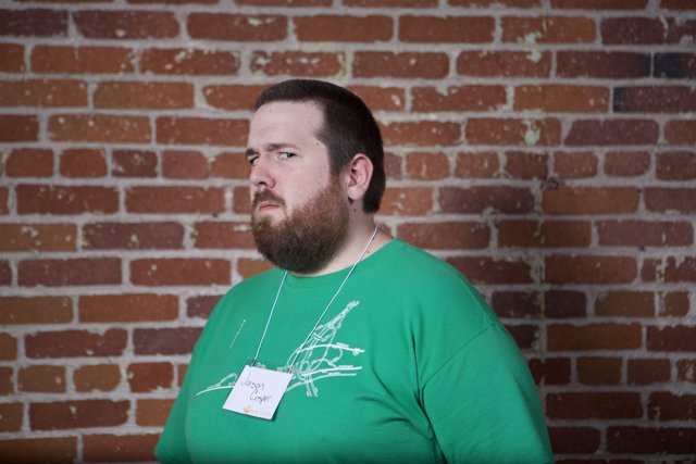 Green Shirt, Brick Wall, and a Bearded Man