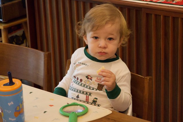 Toddler Enjoying Snack Time in Festive Gaming Shirt
