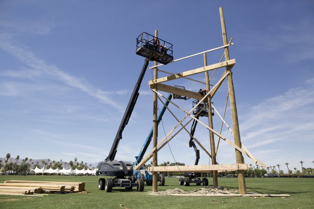 Construction Crane Hoists Wooden Structure on Field