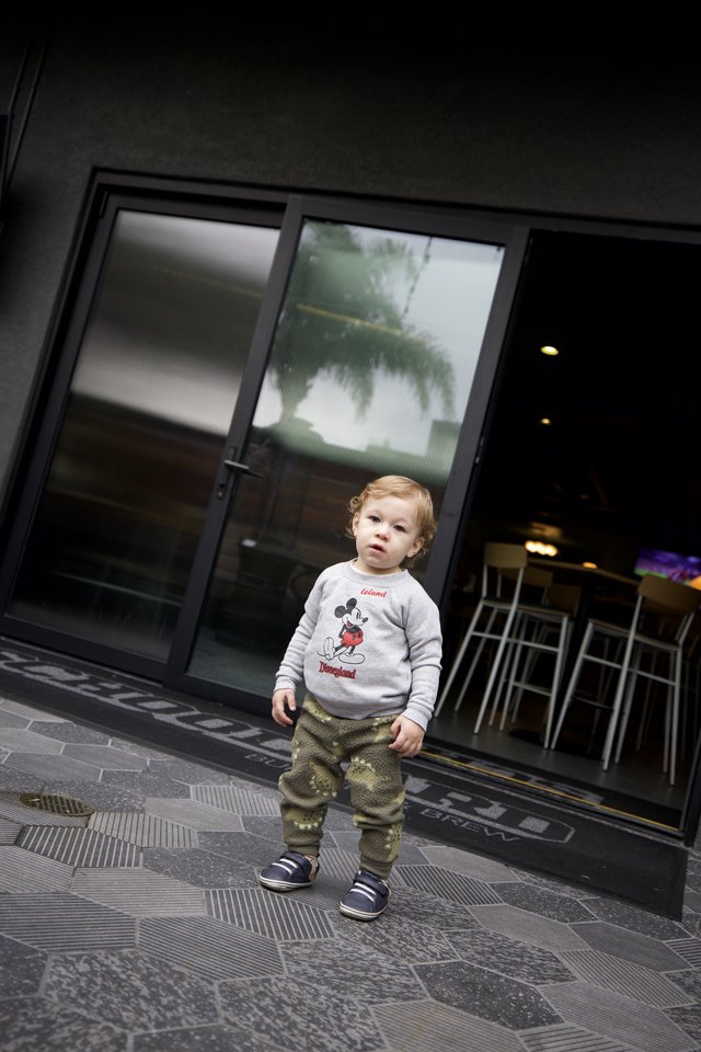 Young Child Outside Modern Storefront in SLO