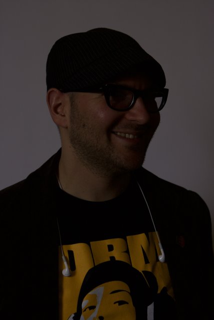 Smiling man in black hat and glasses