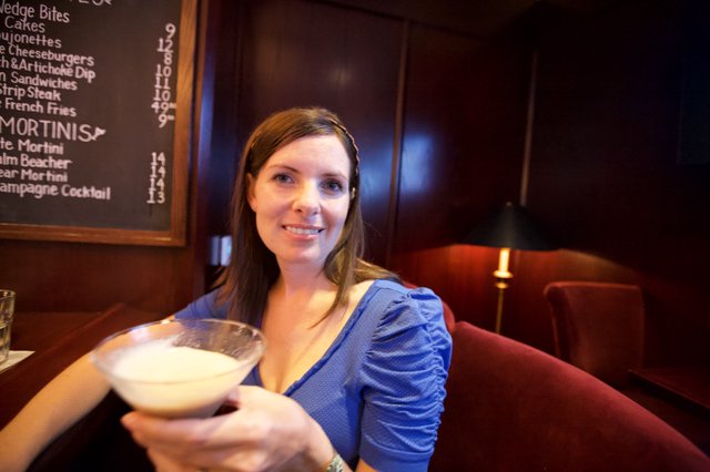 Woman Raising a Creamy Martini at Upscale Bar