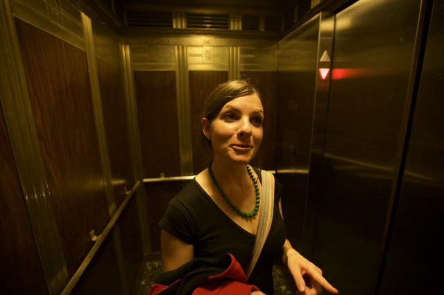 Woman Smiling in Vintage Elevator at Night