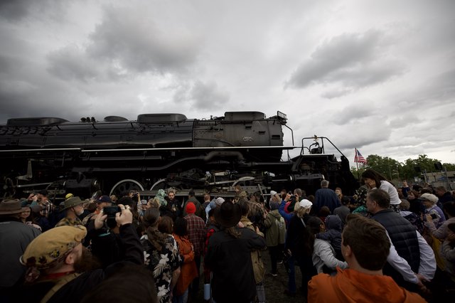 Crowd Gathers Around Historic Steam Locomotive Under Dramatic Sky