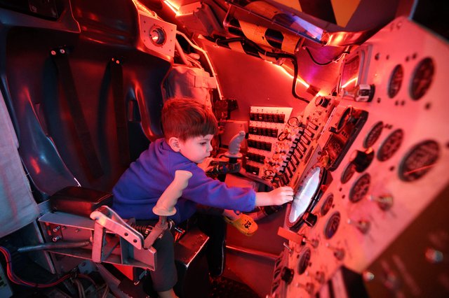 Child Exploring Submarine Simulator at Science Center