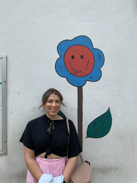 Portrait of a Happy Woman in Front of Painted Flower