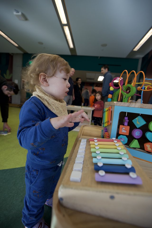 Toddler Exploring Colorful Xylophone at Children's Play Center