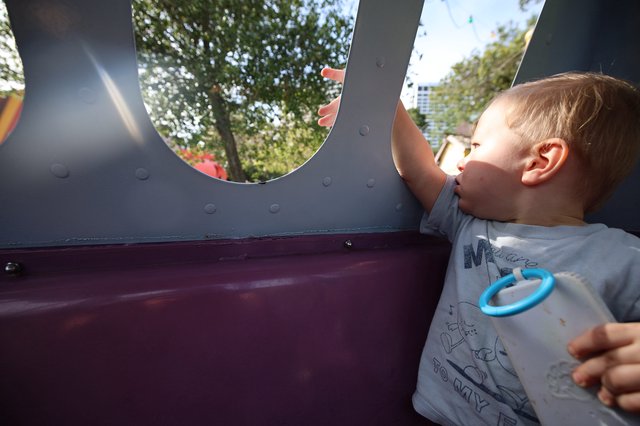 Young Boy Looking Through Playground Structure Window