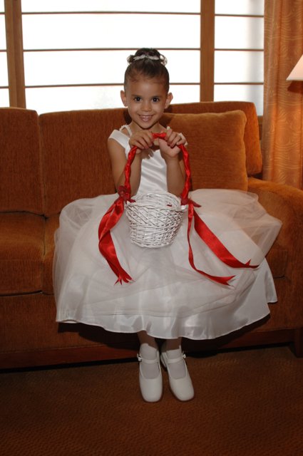 Little girl in a white dress with a basket sitting on a couch