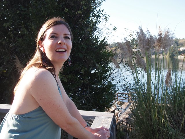 Laughing Woman on Waterfront Deck in Autumn Sun