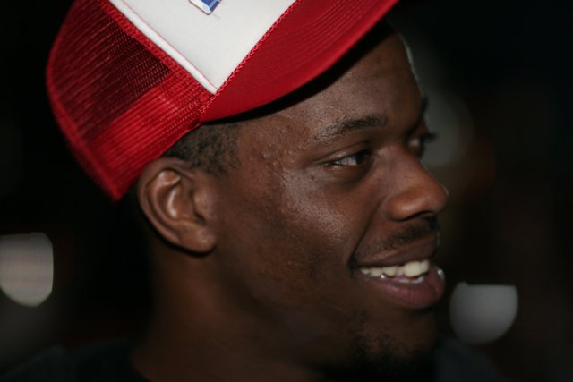 Smiling Man in Red and White Baseball Cap