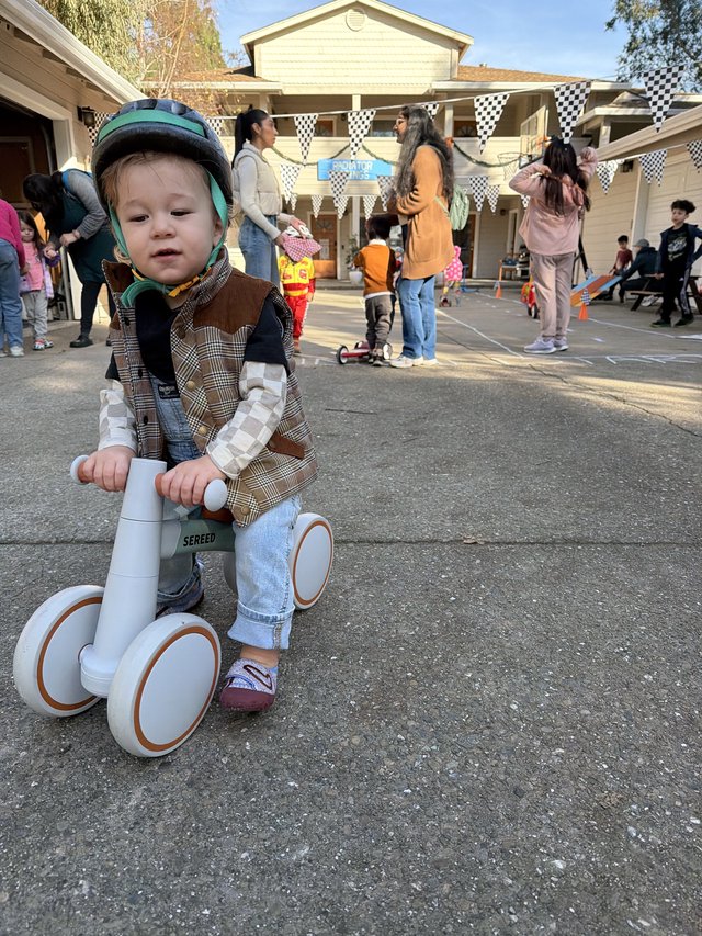 Young Child on Balance Bike at Neighborhood Party