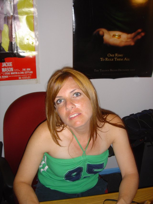 Young Woman Seated Beneath Lord of the Rings Poster