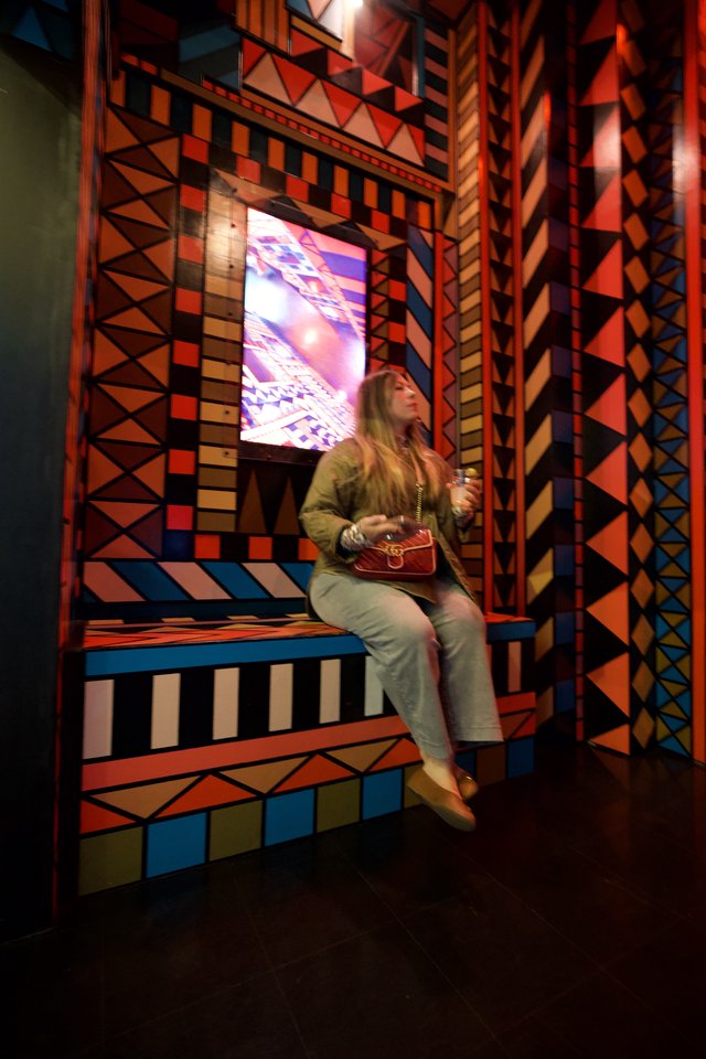 Woman in Vibrant Geometric Installation with Digital Display