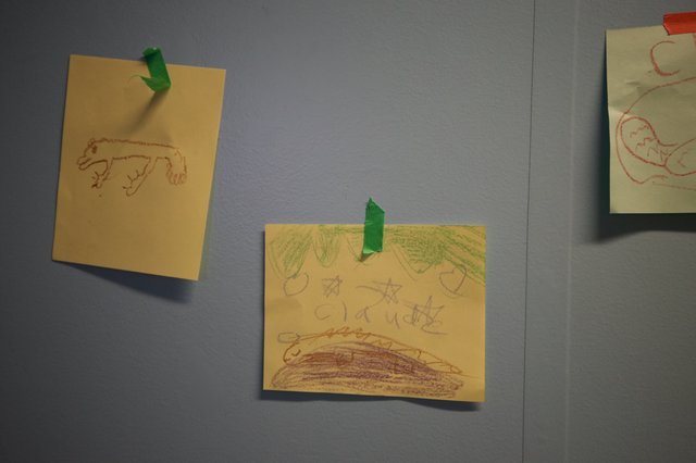 Children's Crayon Drawings Displayed on Gray Wall