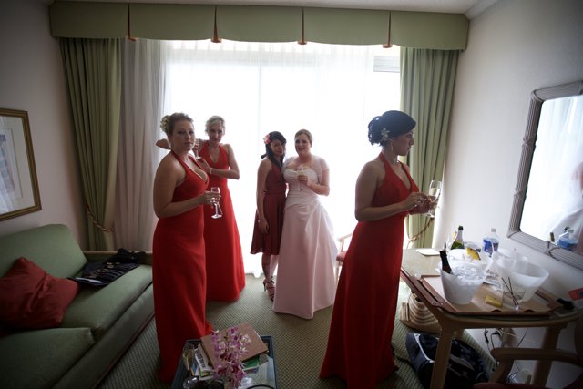 Group of Women in Red Dresses Standing in a Formal Living Room