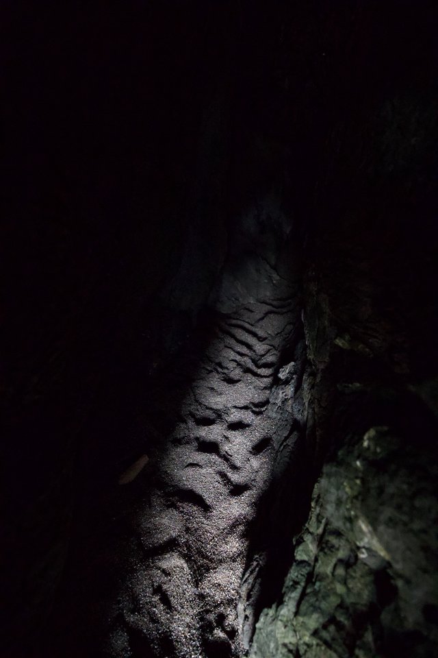Dark Cave Passage Illuminated by Spotlight