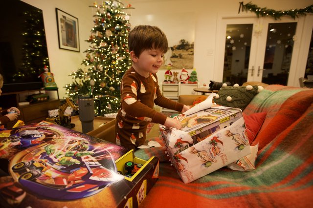 Christmas Morning Joy: Boy Unwrapping Presents