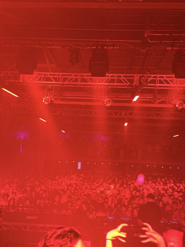 Red-Lit Concert Crowd Under Stage Lighting Rig