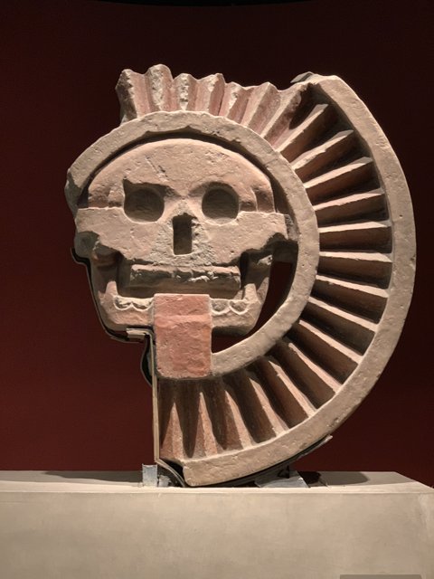 Ancient Stone Sculpture of a Head with Symbolic Wheel Emblem