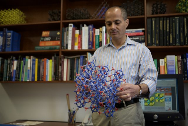 Omar M. Yaghi showcases model of molecule in front of impressive bookshelf