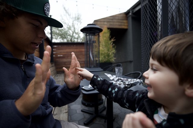 Joyful High Five Between Adult and Children Outdoors