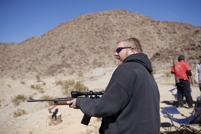 Man with Rifle taking in the Desert View